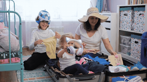Family of three packing a suitcase for vacation