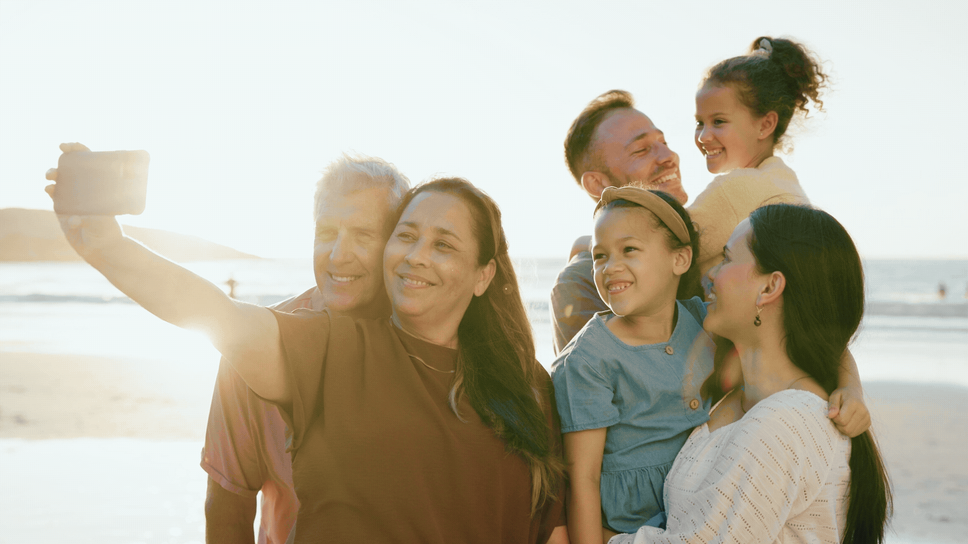 Family on the beach taking a selfie. 