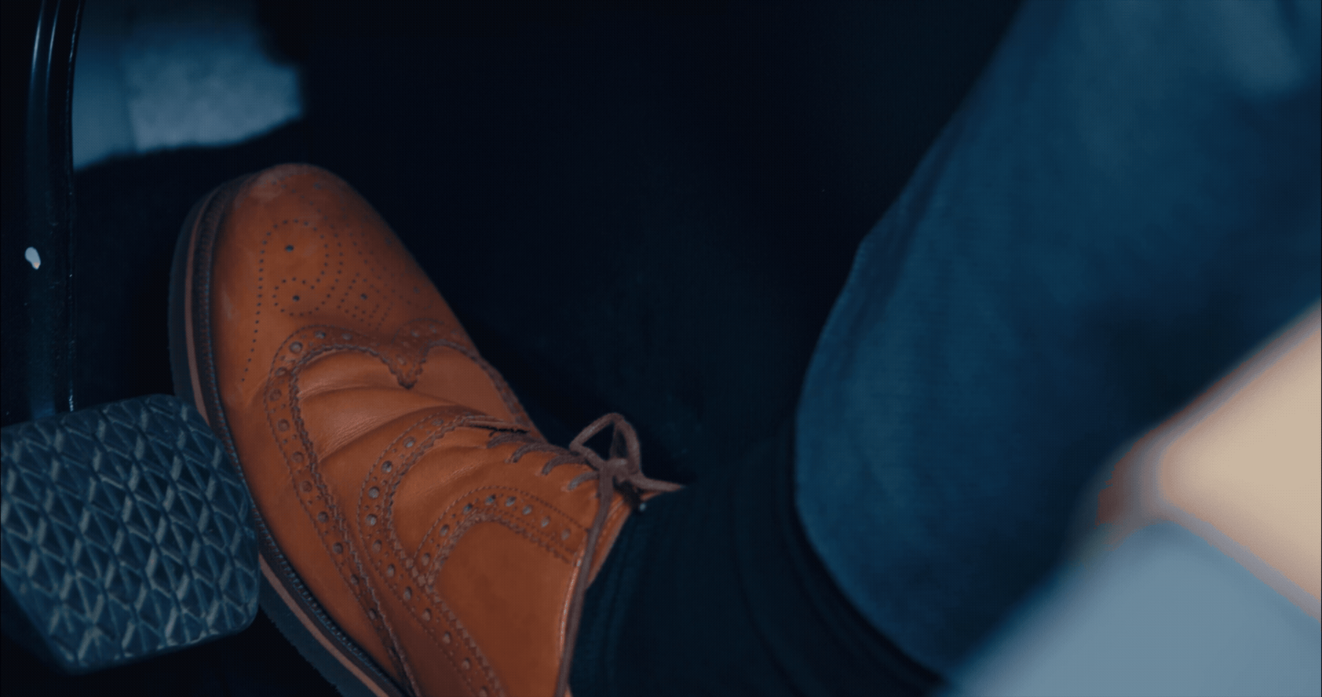 business man in brown leather shoes pressing the acceleration pedal in a modern car