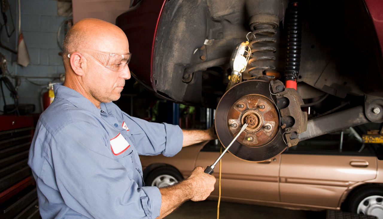 A car mechanic working on a car brake