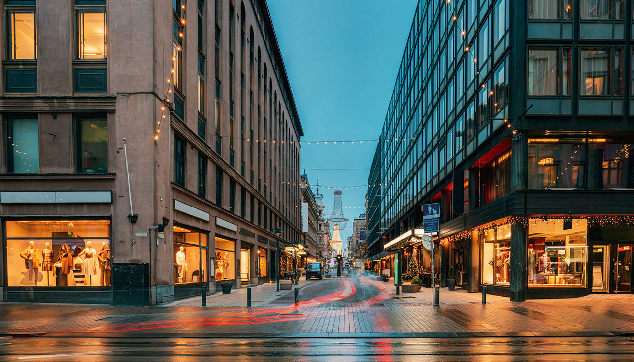 Intersection of Aleksanterinkatu Street and Iso Roobertinkatu at night with lights reflecting on street