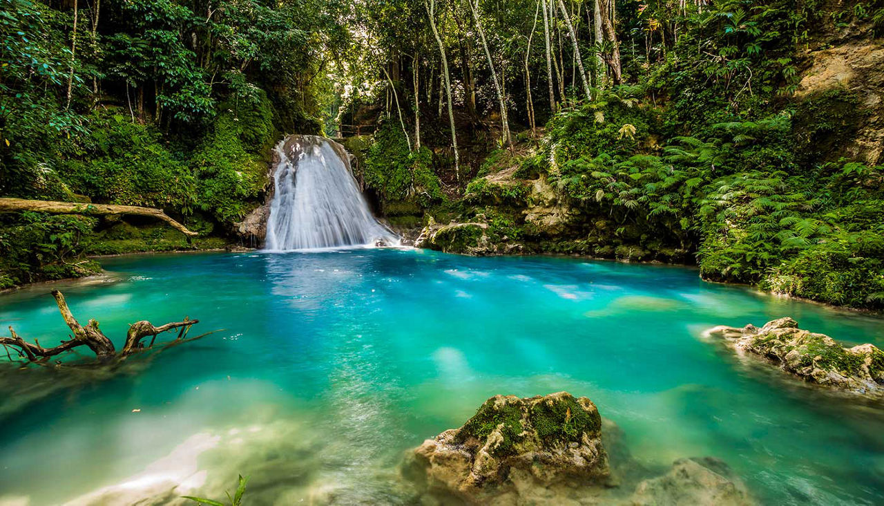 Waterfall in a forest, bright blue water hole