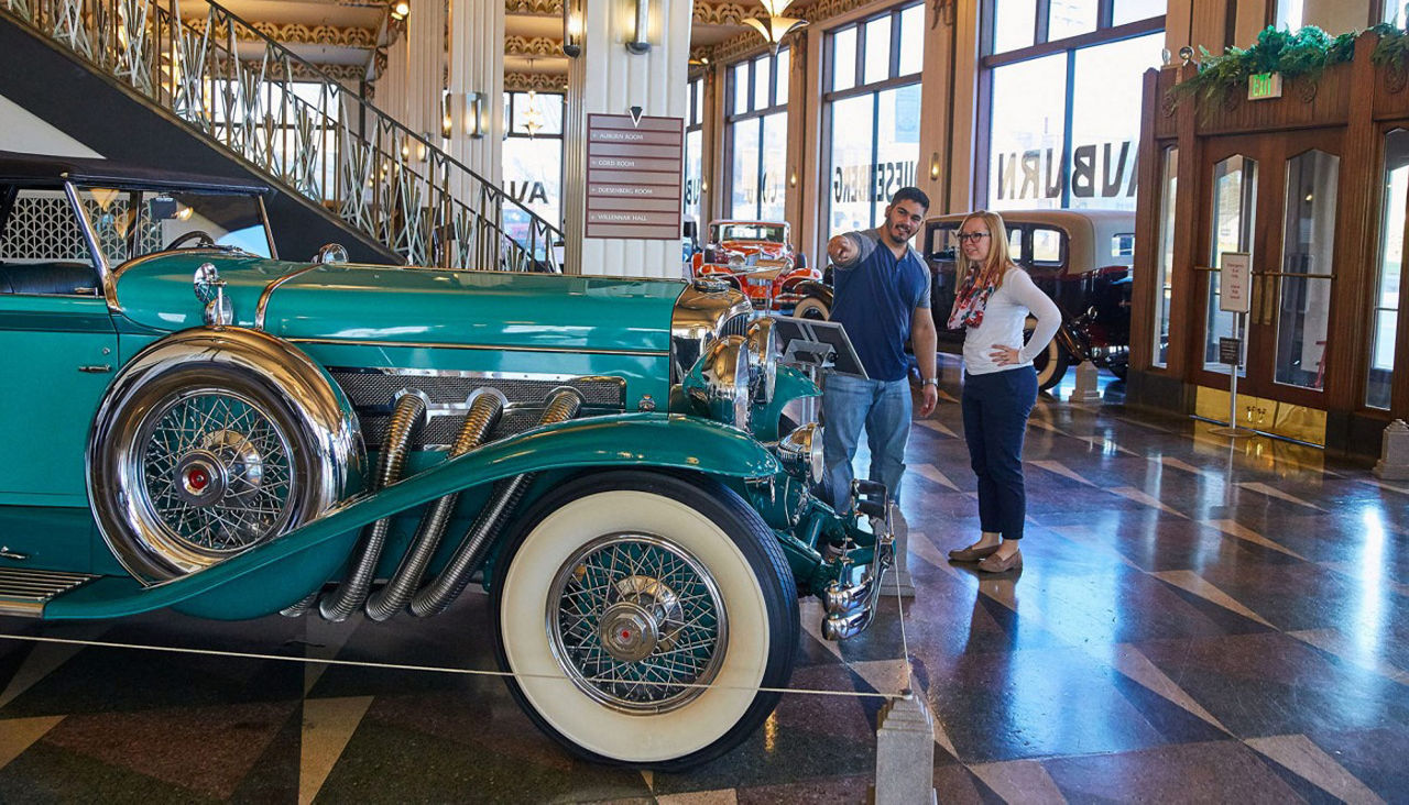 couple standing in the Auburn Cord Dusenberg Automobile Museum  