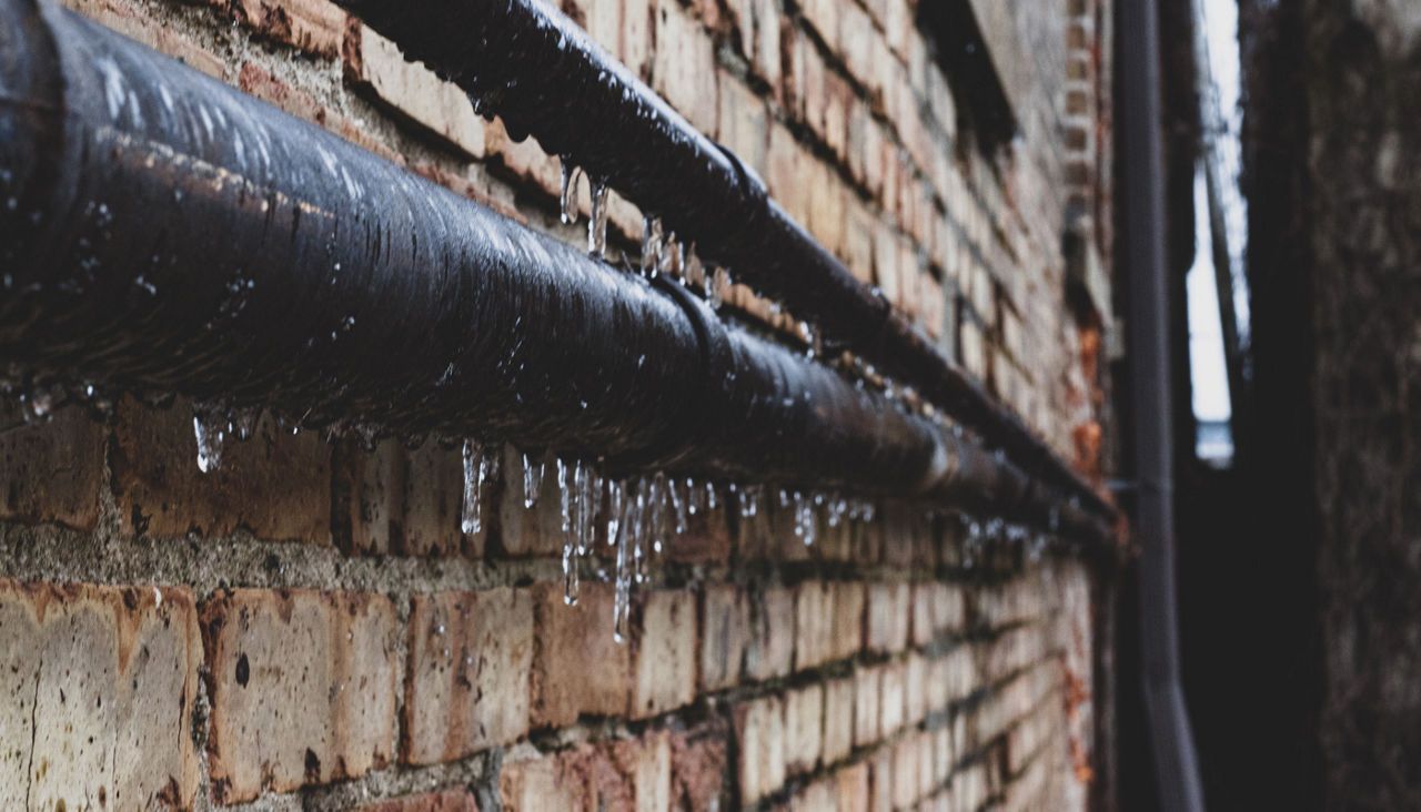 Frozen water pipe on side of building