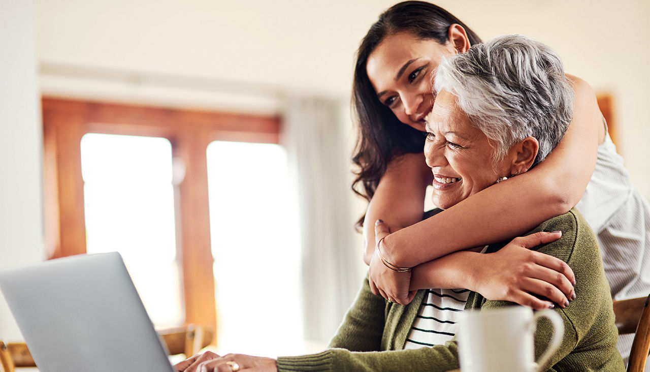 Woman hugging and helping senior relative with her finances