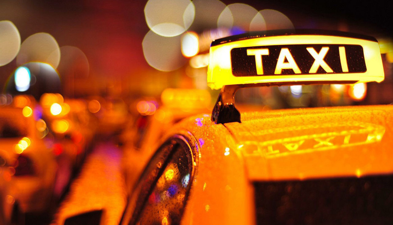 Closeup of yellow taxi in a city setting