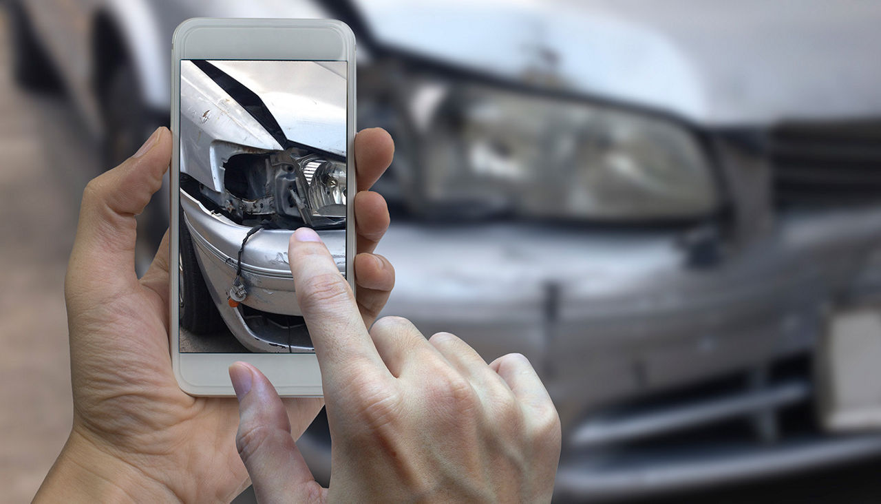 Taking a photo of car accident damage with smartphone