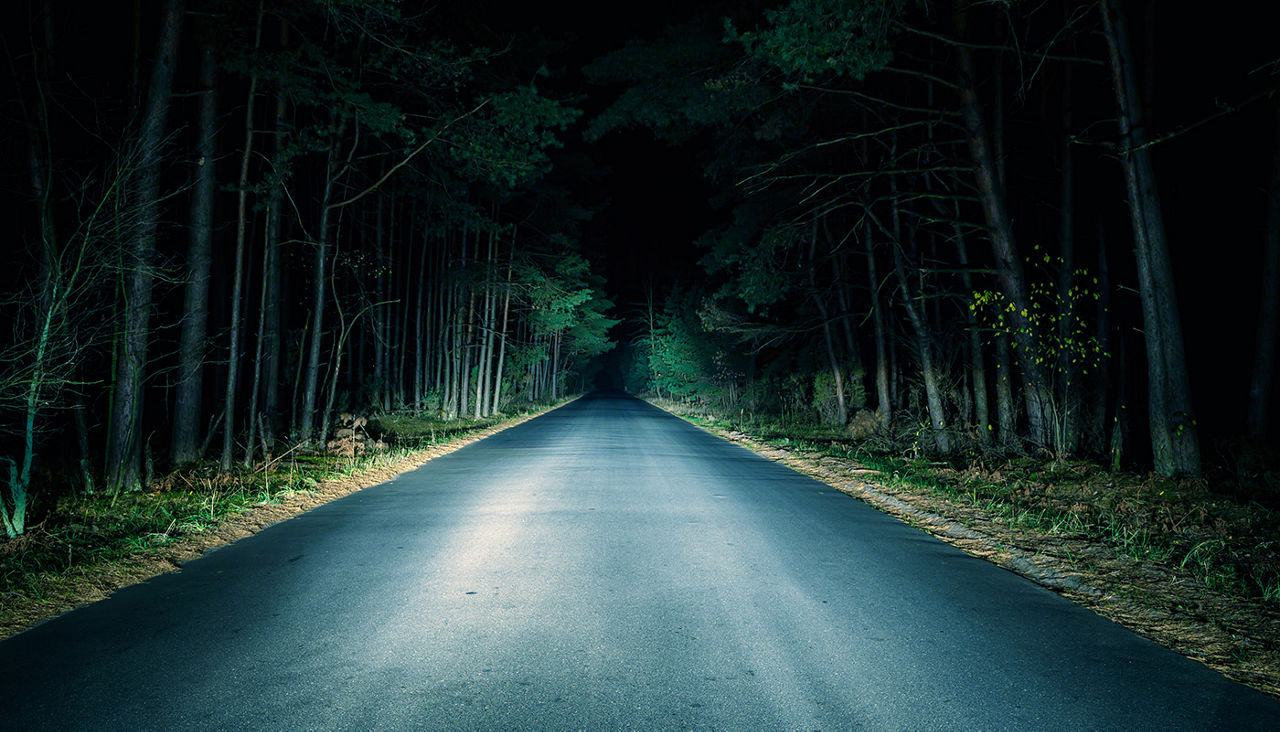 Dark road illuminated by headlights