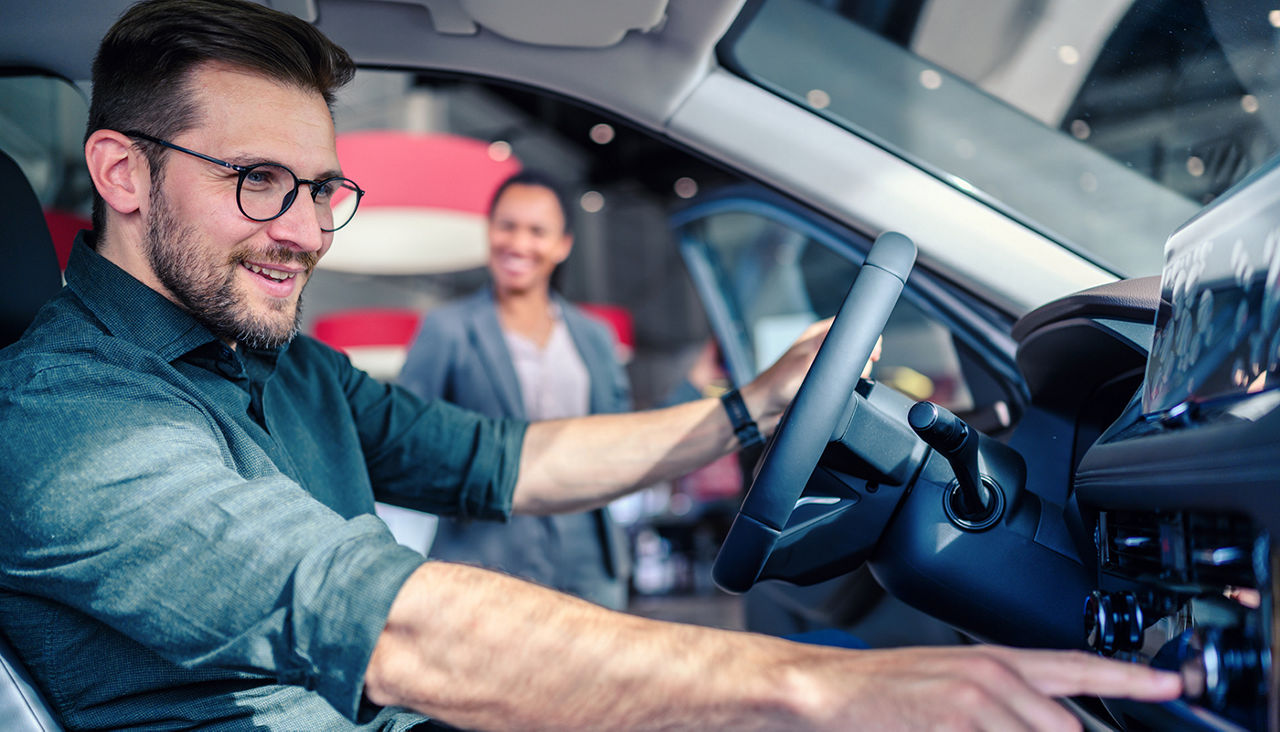 Saleswoman helping the male customer to choose a new car