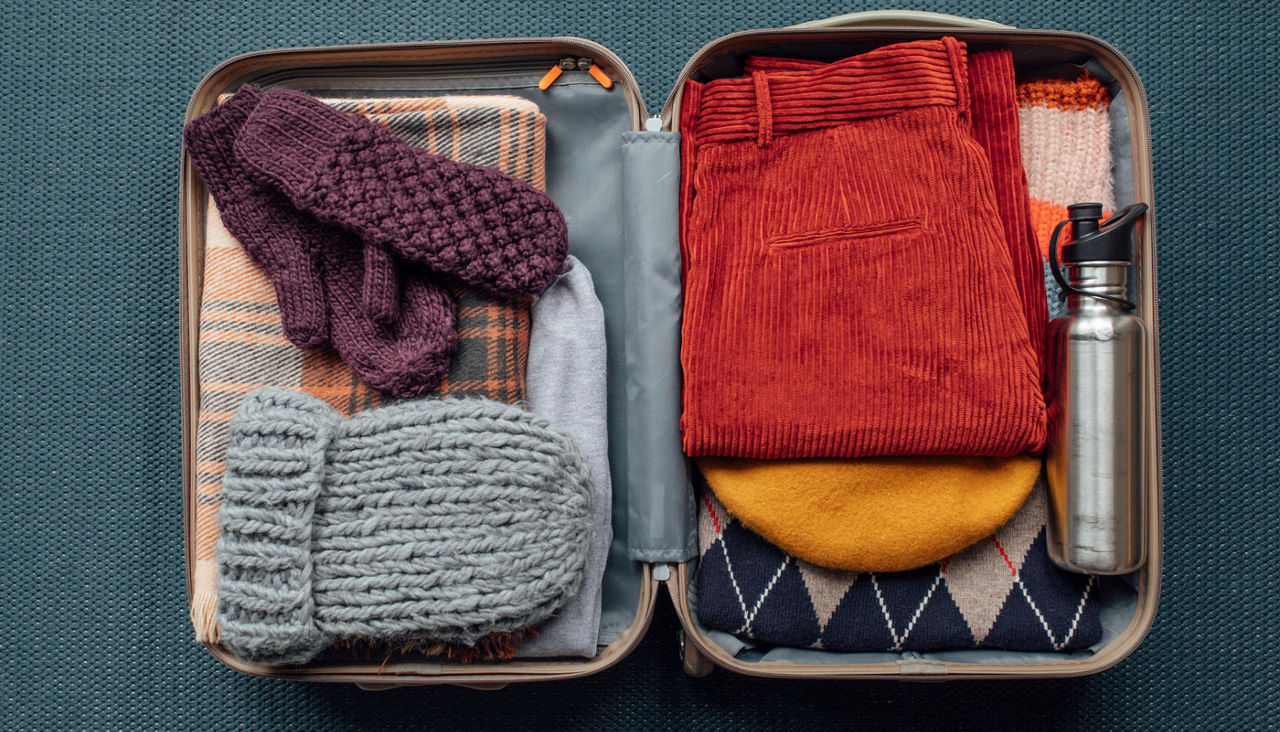 cold weather attire packed neatly in a suitcase