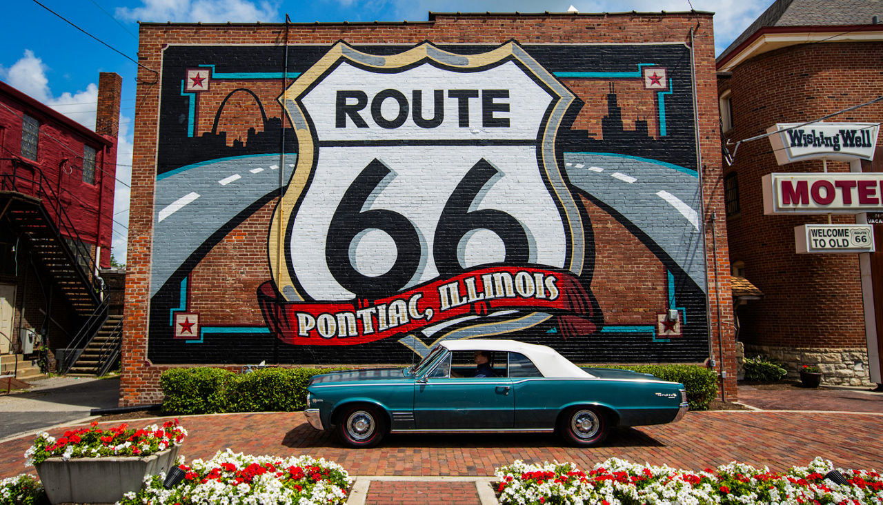 Vintage Pontiac car parked in front of Route 66 Mural sign in Illinois