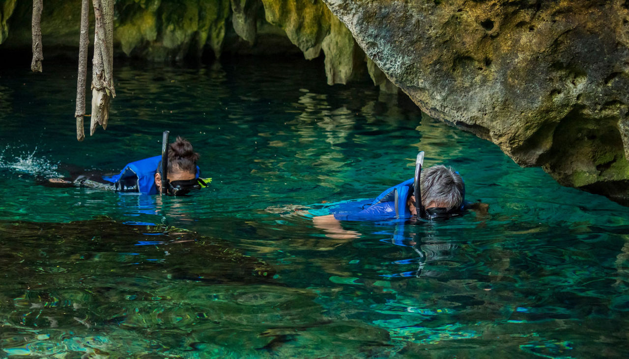 Some people is snorkeling on a cenote in Cancun Mexico