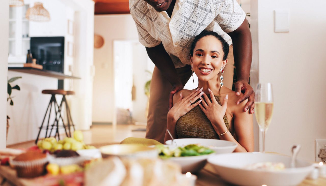 Happy couple at dinner table with food on the table.
