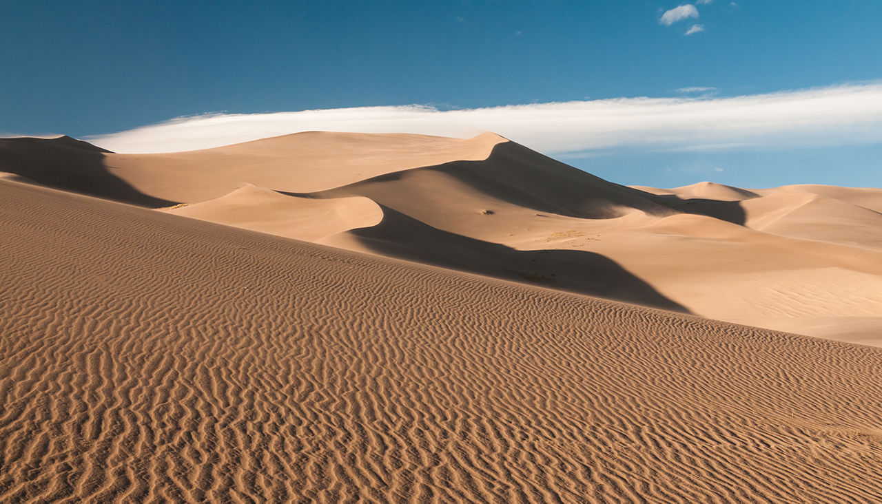Impressive Sand Dunes with clouds and blue sky, seen in Great Sand Dunes National Park, Colorado, USA. 