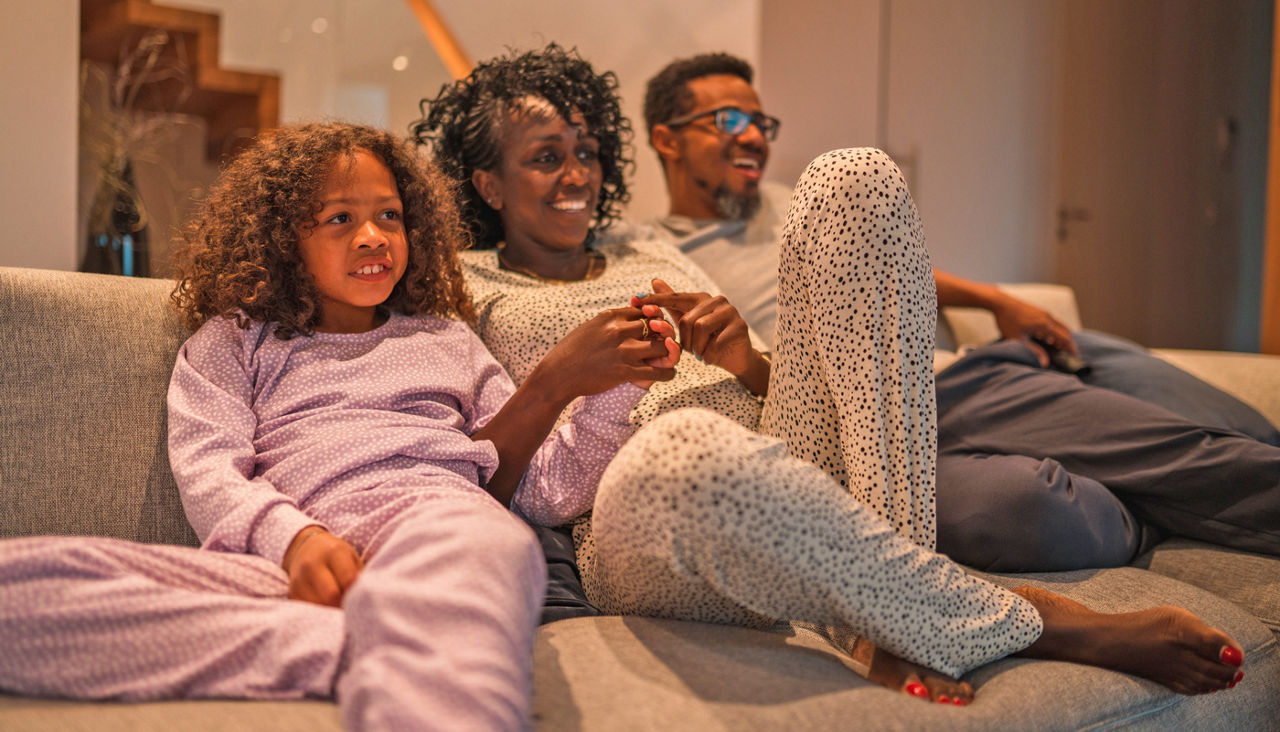 Small Family Of Three Watching A Movie In The Living Room