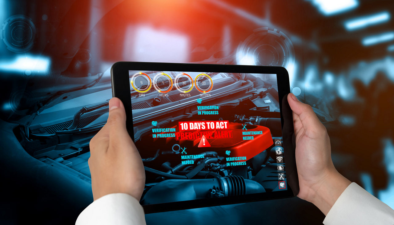 A person analyzing an engine using a futuristic tablet that can sense problems with the vehicle.