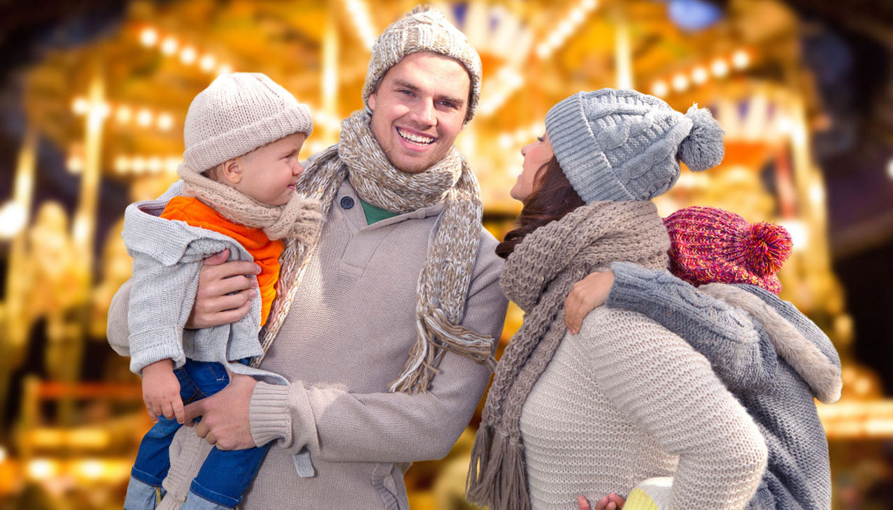 Family of four enjoying an amusement park at night in the winter