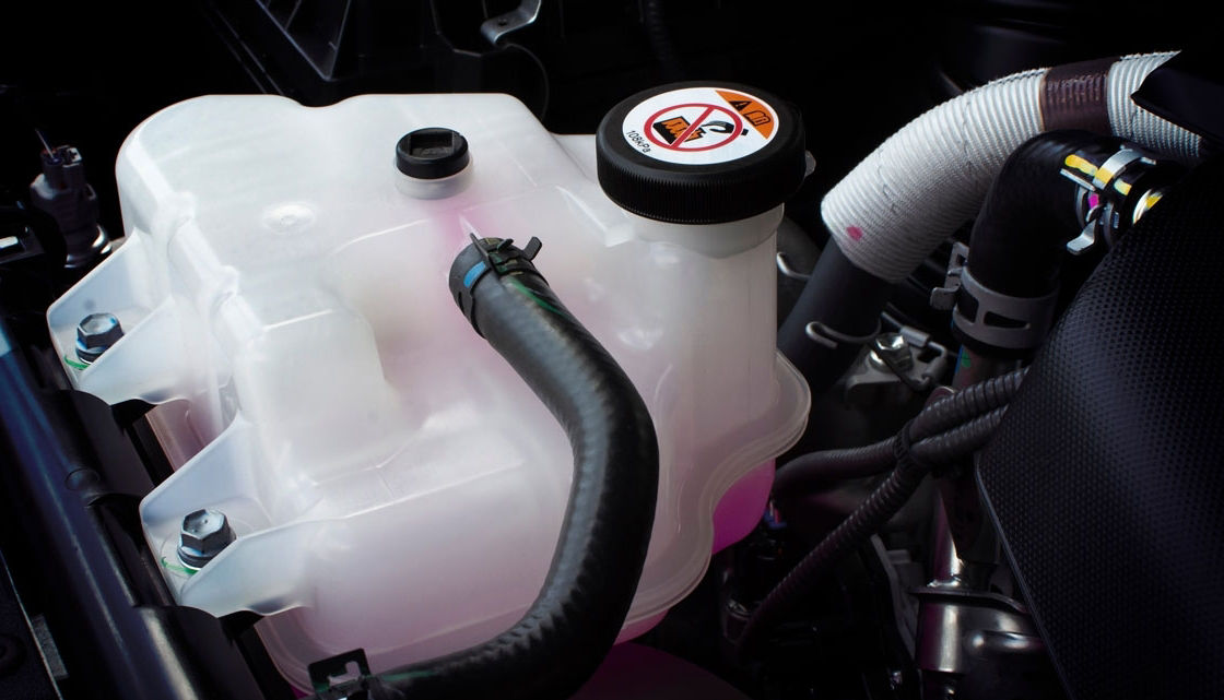 Coolant tank with a pink liquid antifreeze of a radiator system in car