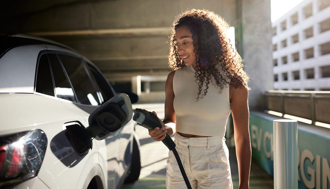 woman charging her EV at a station