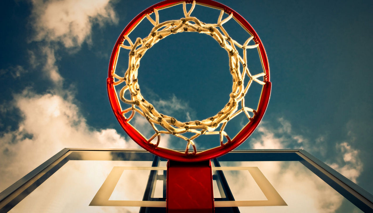 basketball hoop with blue sky and white clouds