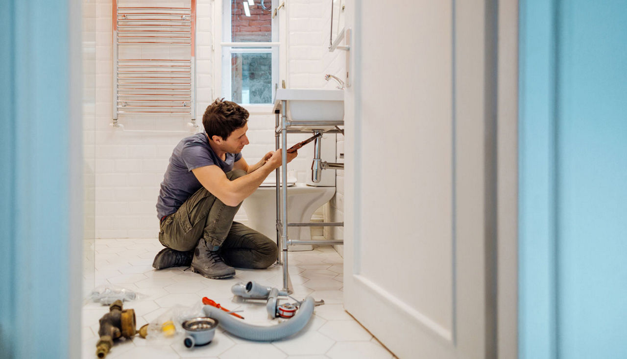 man working on bathroom plumbling