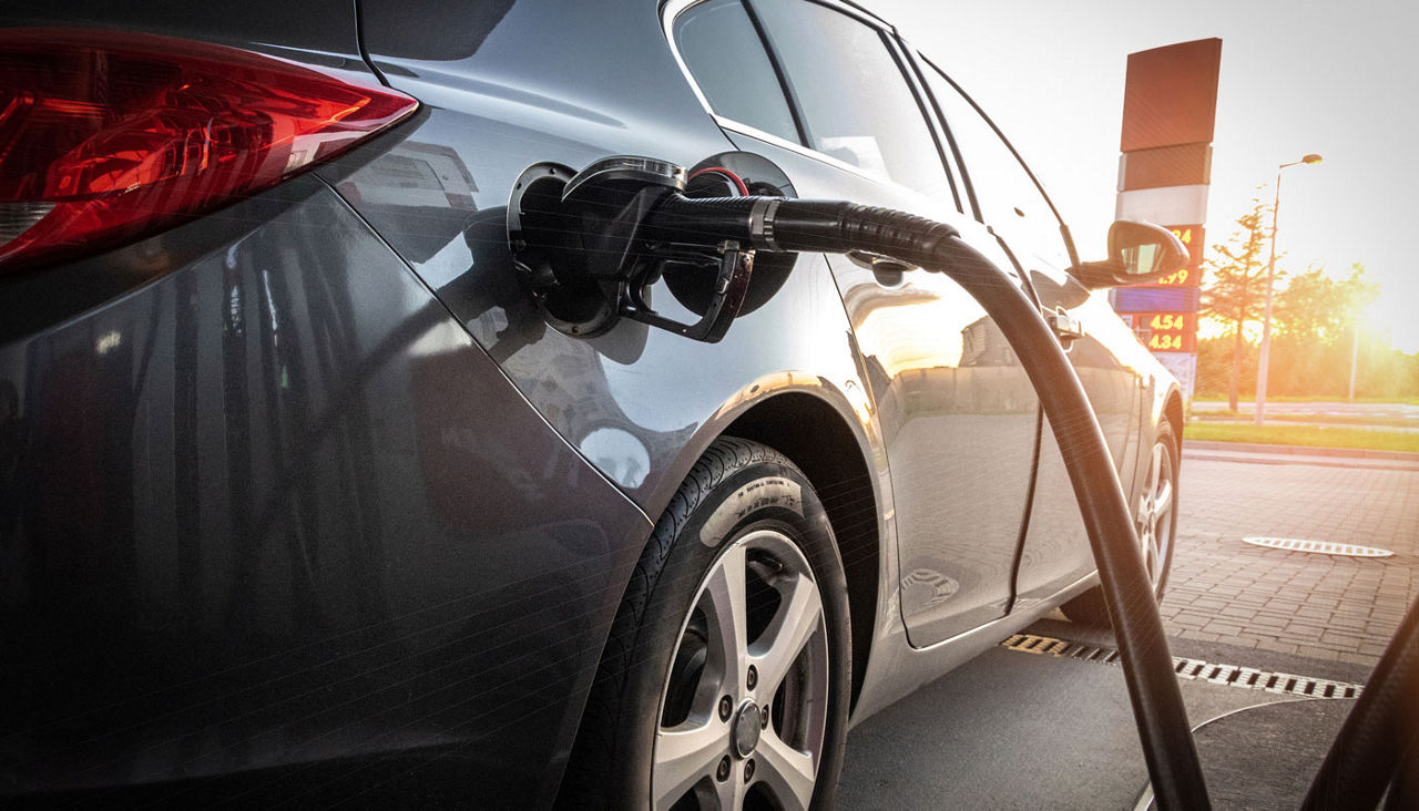 Car at gas station with pump in the tank