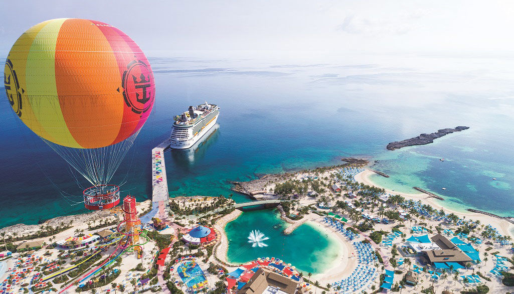 Perfect Day at CocoCay, Bahamas, private island, aerial, drone shot of island, Up, Up, and Away balloon aloft on left, lagoon, Daredevil''s Tower, Mariner of the Seas docked at pier below

Note: This image was replaced with revised crop/retouching to show more sky above on 2/22/22.