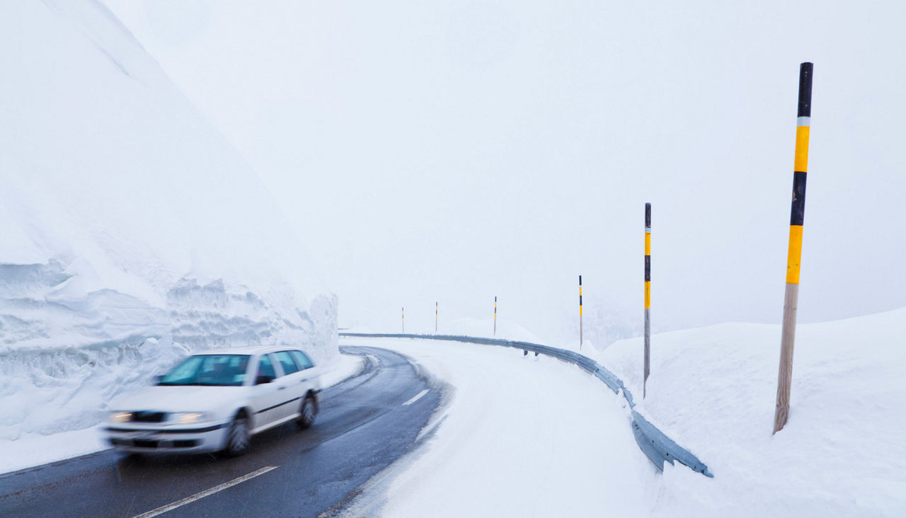Car passing through snow covered road