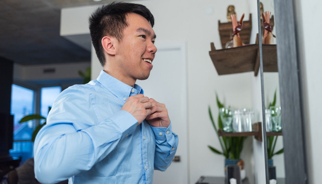 A young man getting dressed for work
