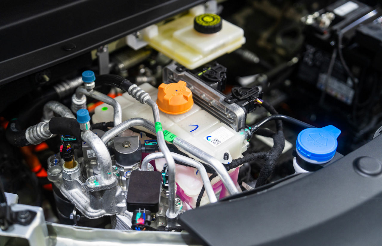 Close-Up of Car Engine Components with Tubes and Reservoir Caps