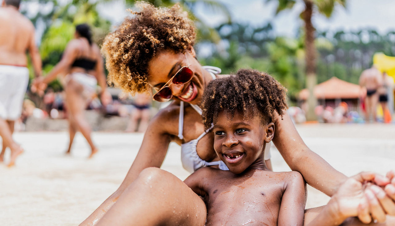 Mother and son playing at water park pool