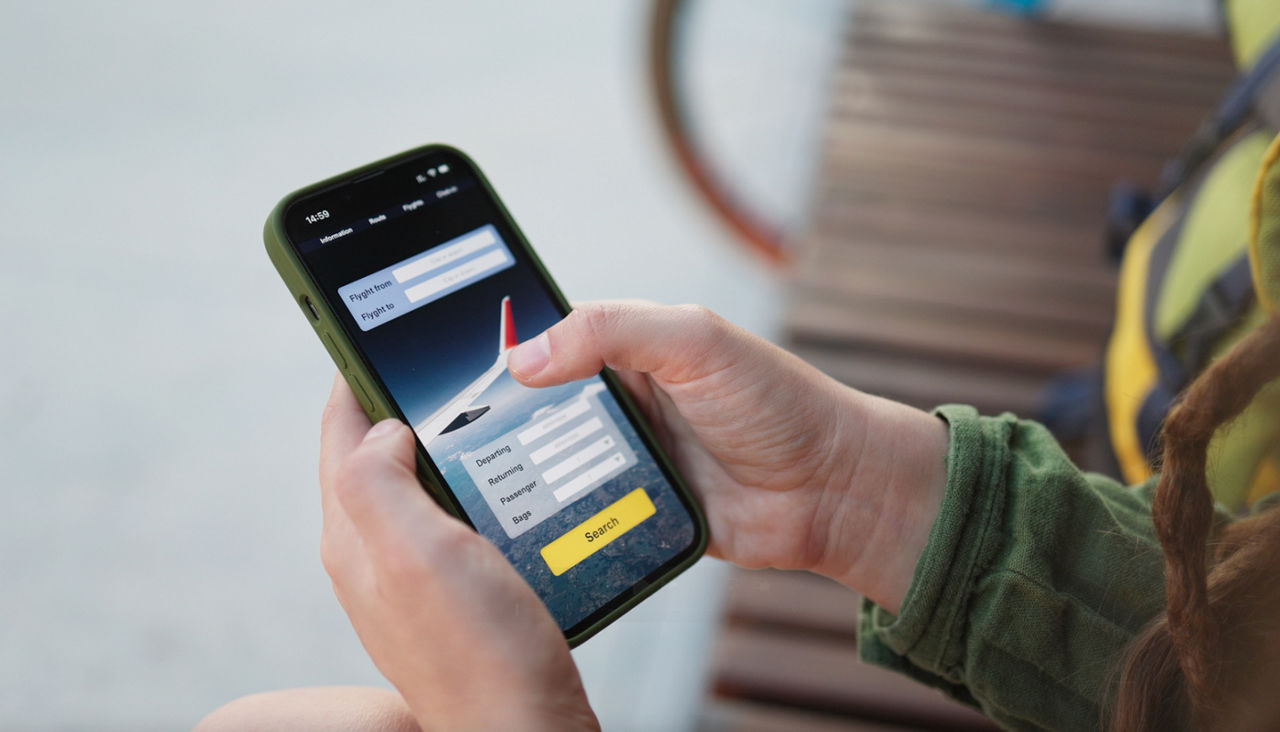 hands holding a cell phone with flight checking information