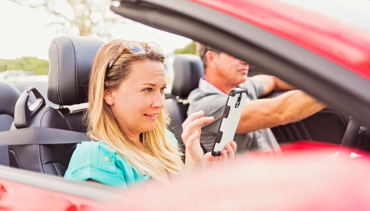 Woman using cell phone in convertible