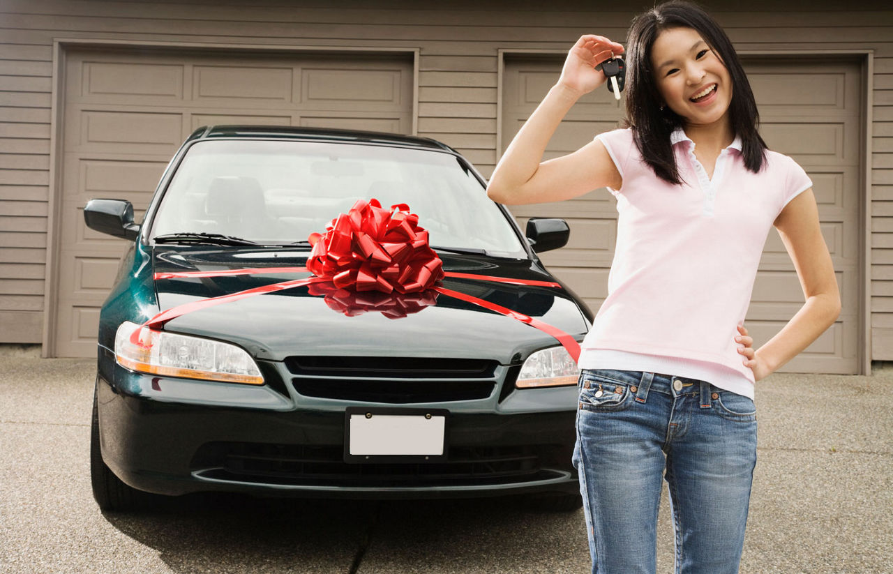 Asian teenager with keys to new car 