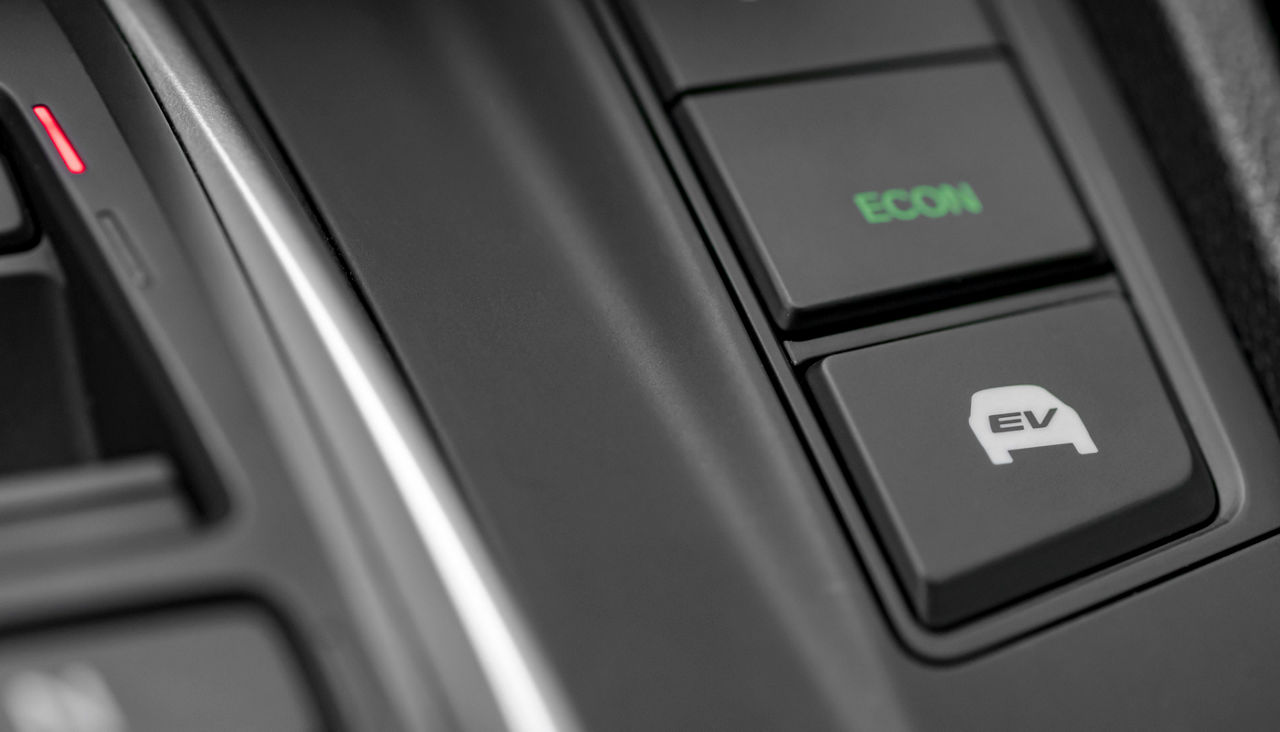 Close up shot of modern hybrid car dashboard selector with fuel efficient and fully electric mode switch buttons