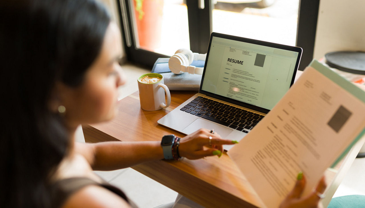 Rear view of a young woman working on her resume