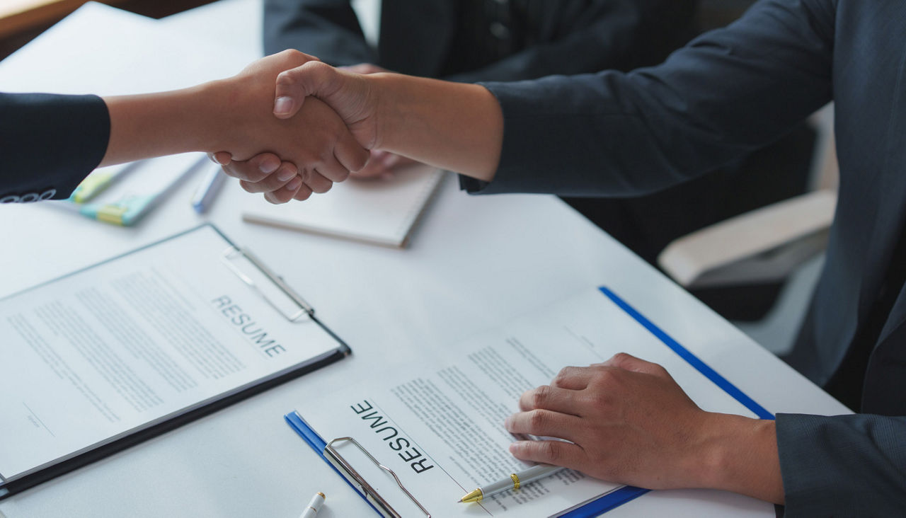 Businesspeople shaking hands after successful job interview and resume review