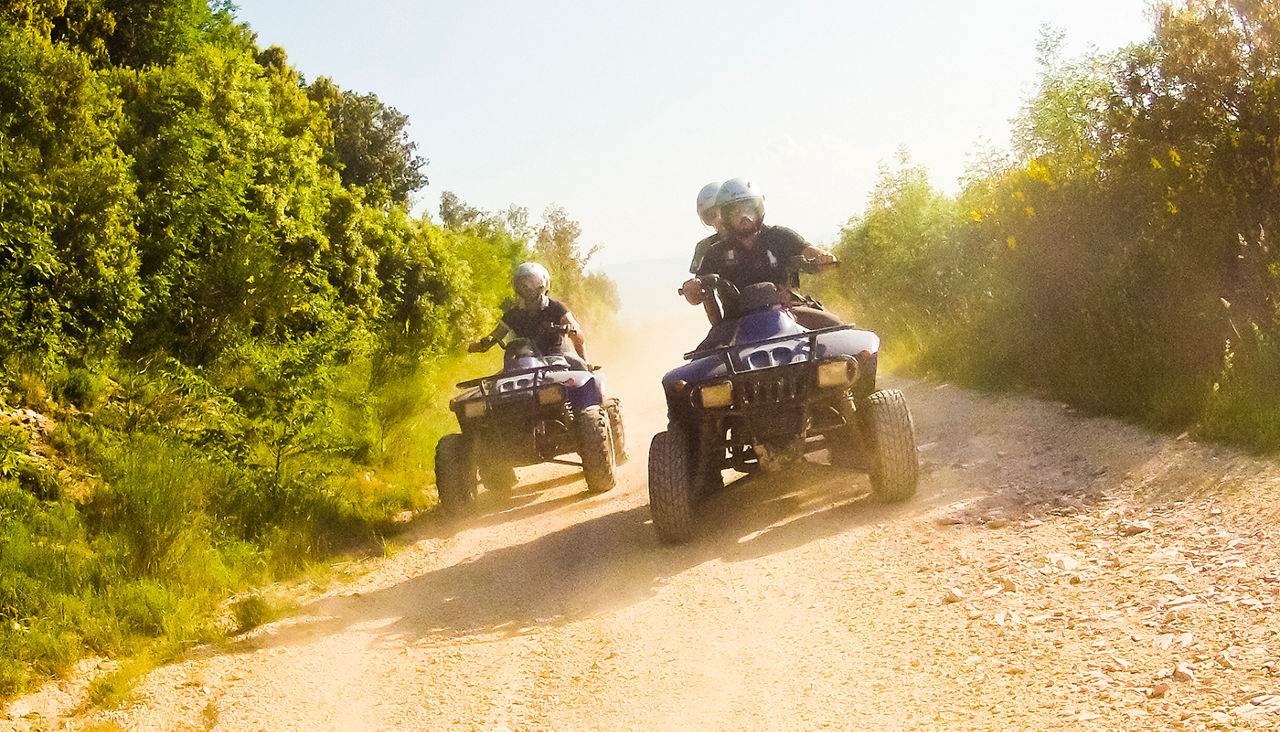 two guys on quad bikes on mountain trail