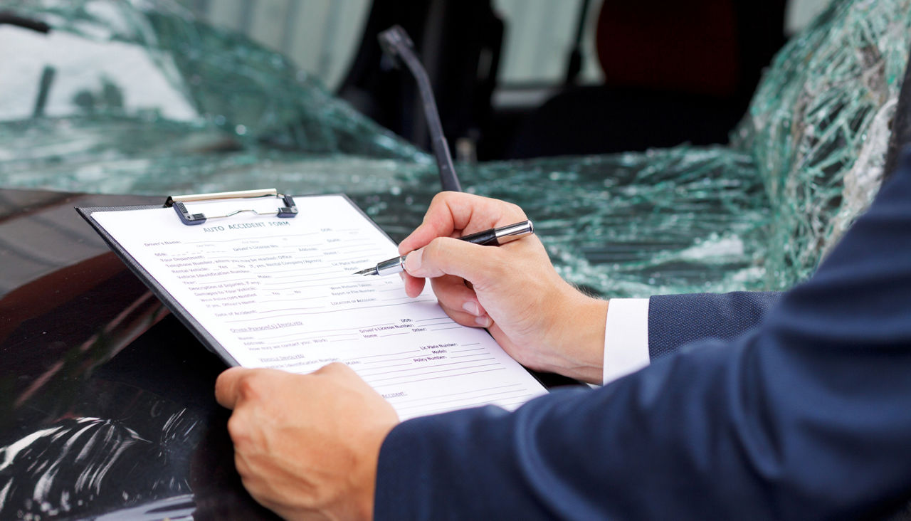 Insurance assessor inspecting damaged vehicle