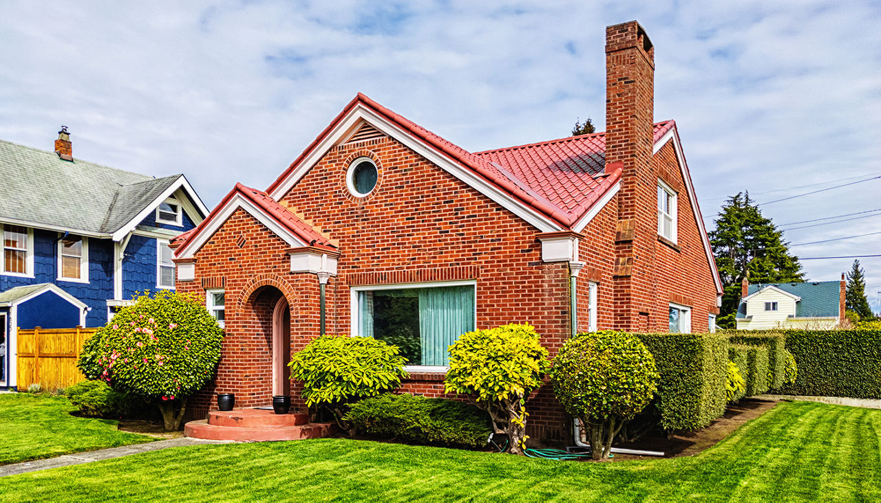 A brick house with a well-kept green lawn.