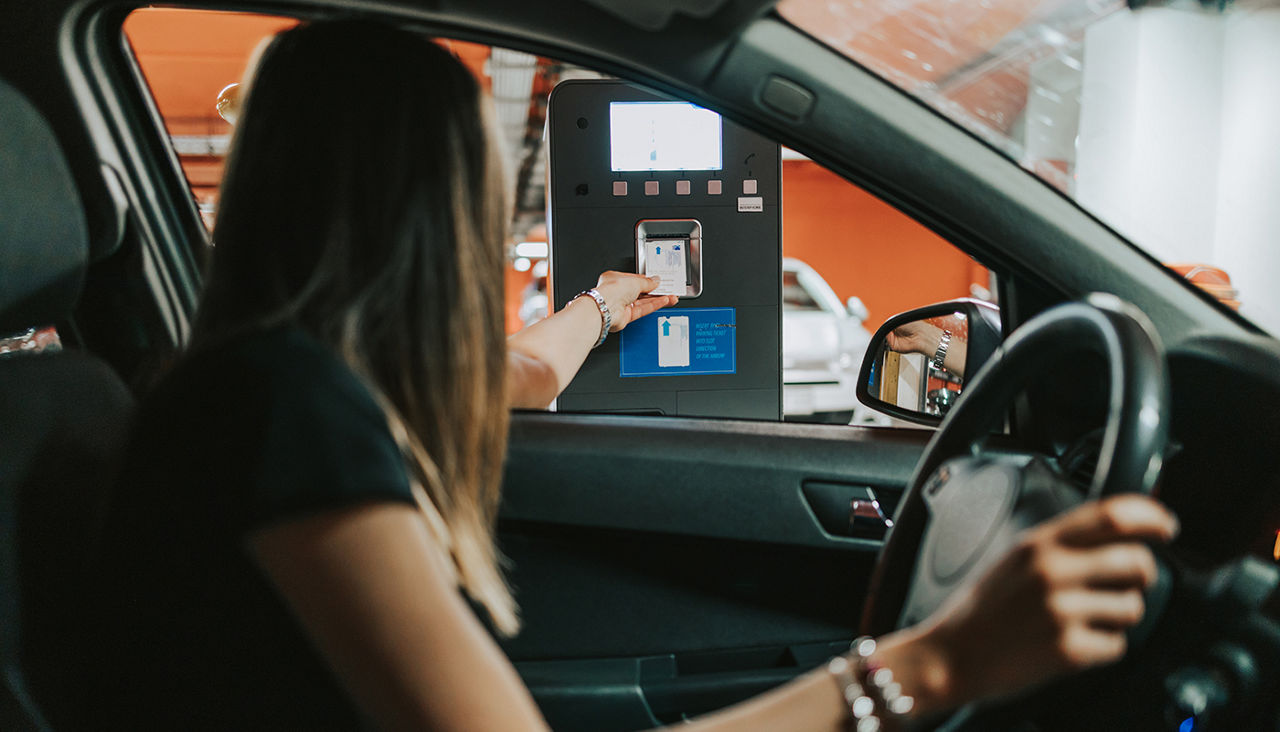 Young female driver using automated parking service to enter into huge underground garage.