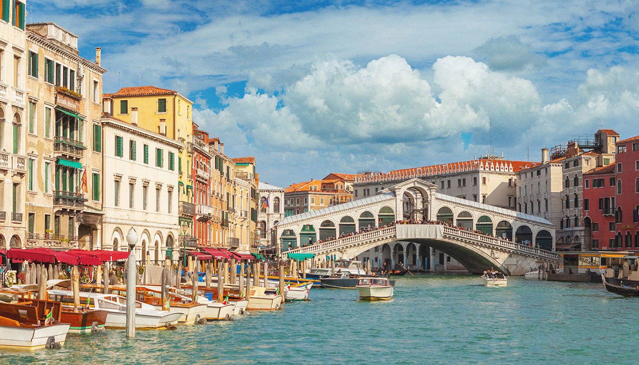 Boats rest in a Venice canal surrounded by old buildings.