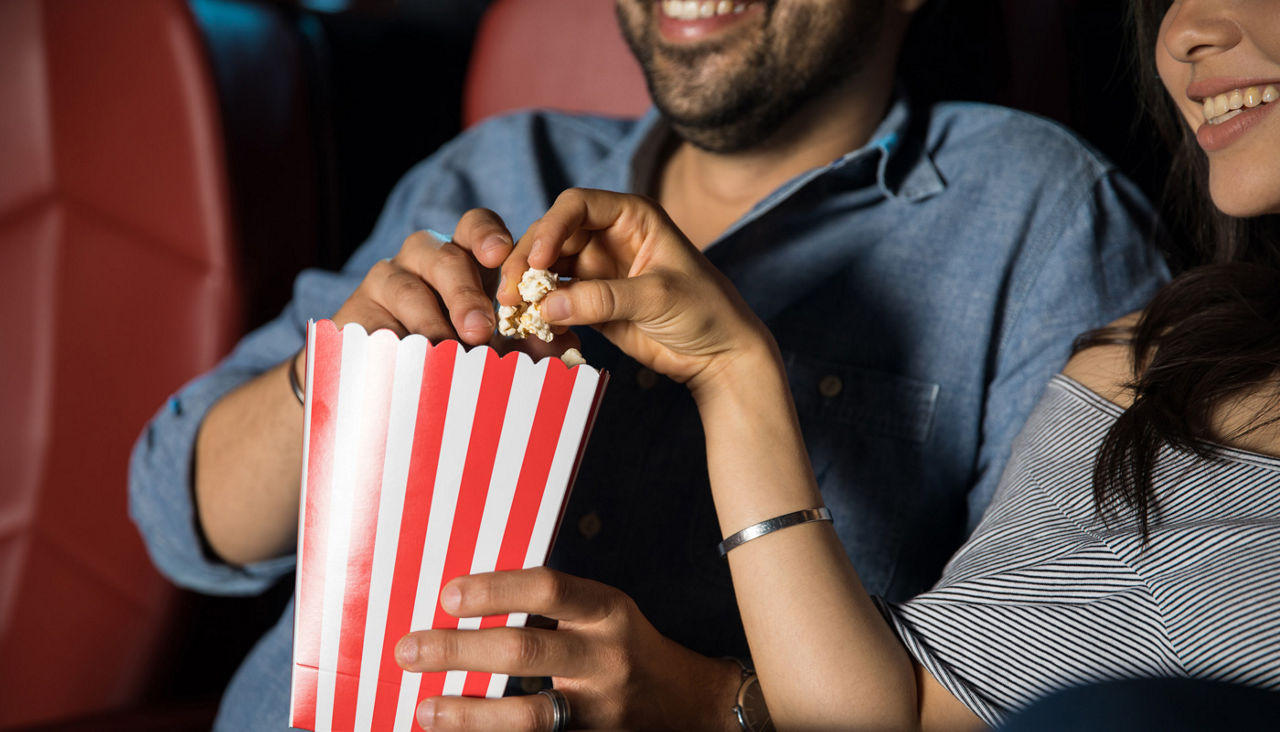 Couple eating popcorn at the movie theater