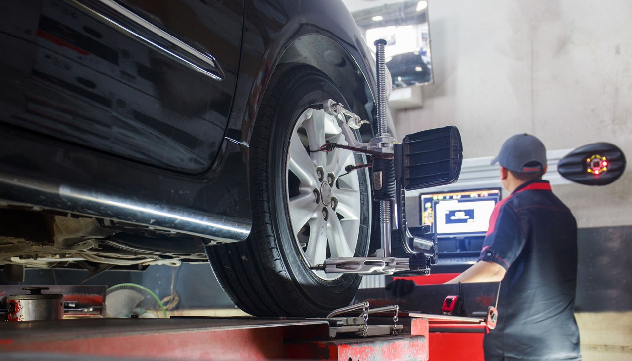 Car on stand with sensors on wheels for wheel alignment camber check in workshop of Service station 