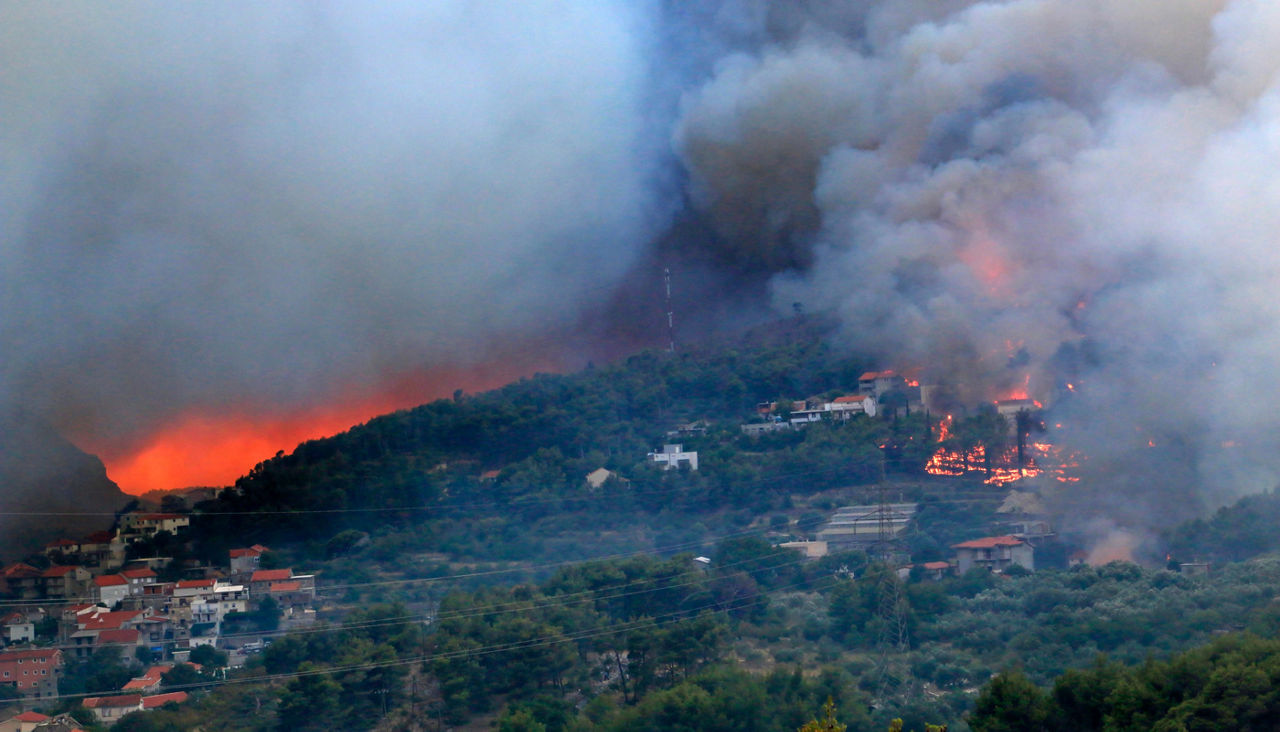 Wildfire burns in a hilly neighborhood