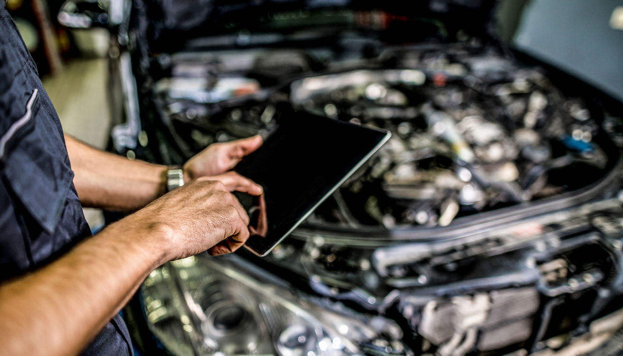 Mechanic using digital tablet in auto repair shop