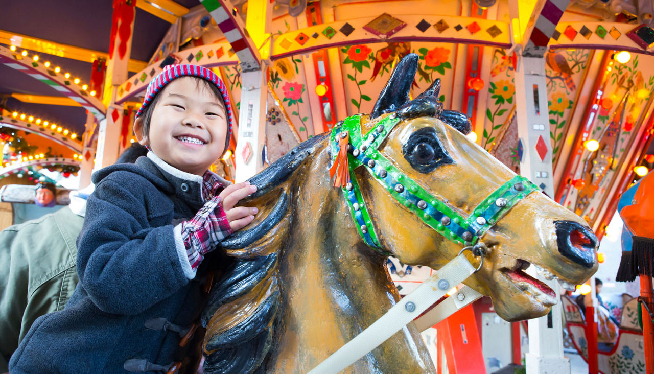 child enjoying a ride on a carousel at an amusement park