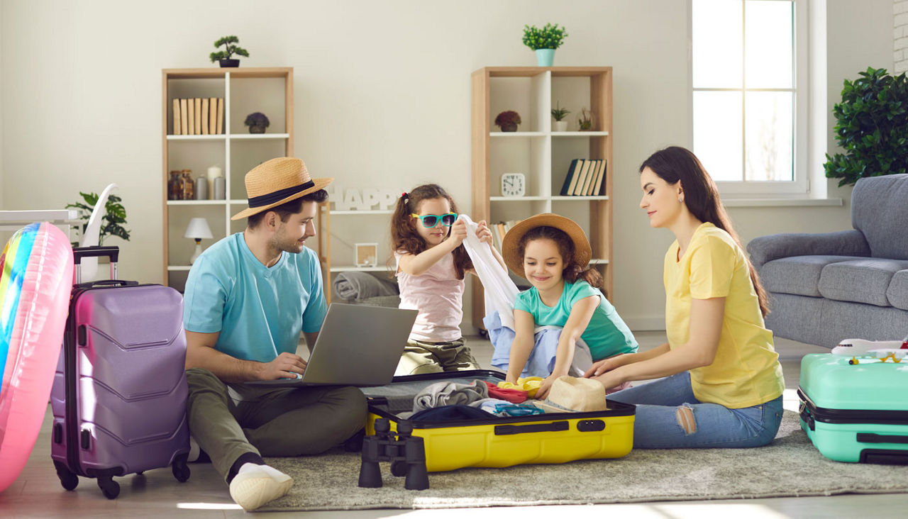 Happy young family packing bags for vacation trip.