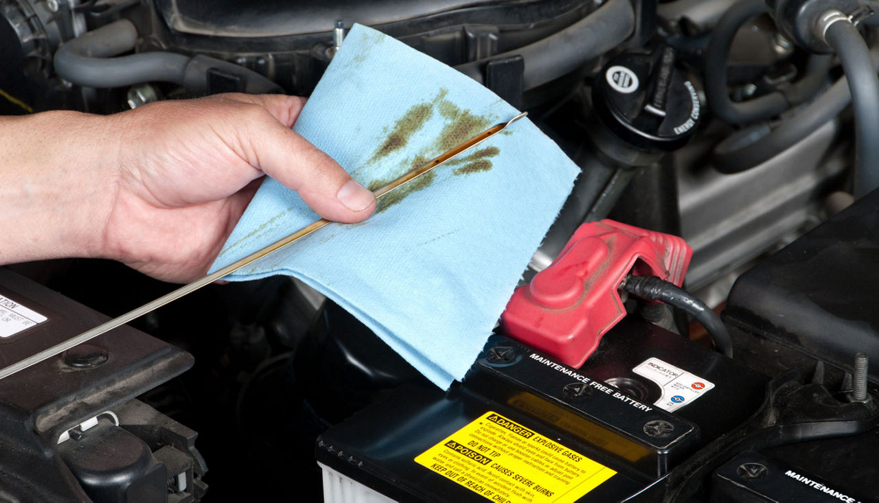 Checking the dipstick of a car's motor oil