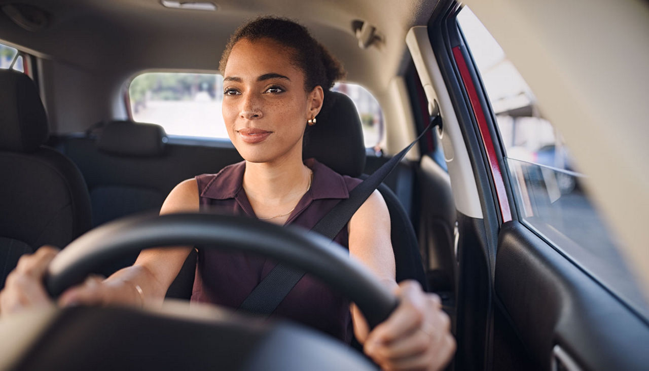 Young black woman driving car